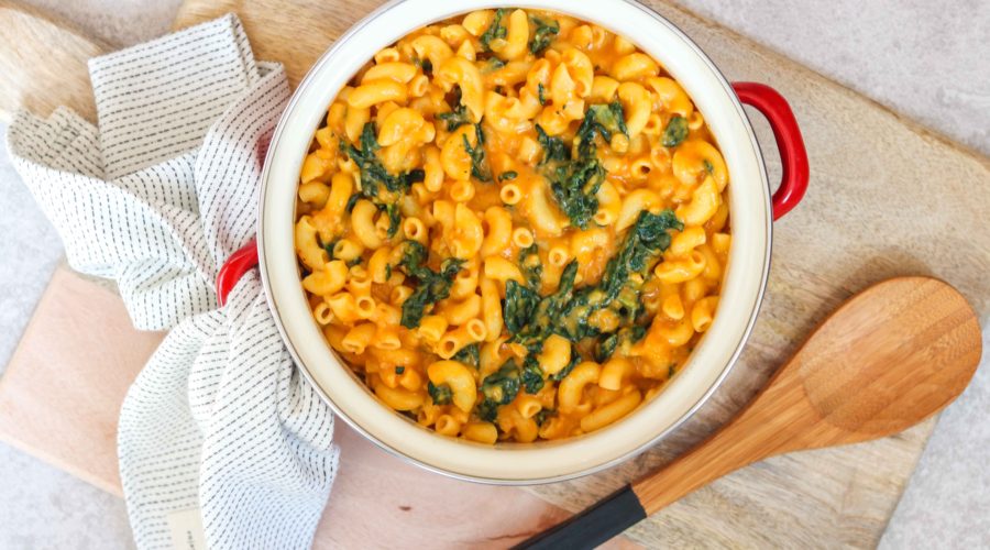 bowl of pumpkin macaroni and cheese with wooden spoon
